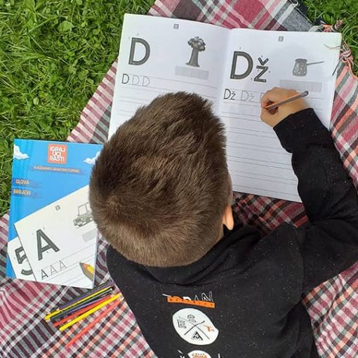 Dječak vježba pisanje slova D kao drvo i Dž kao Džezva