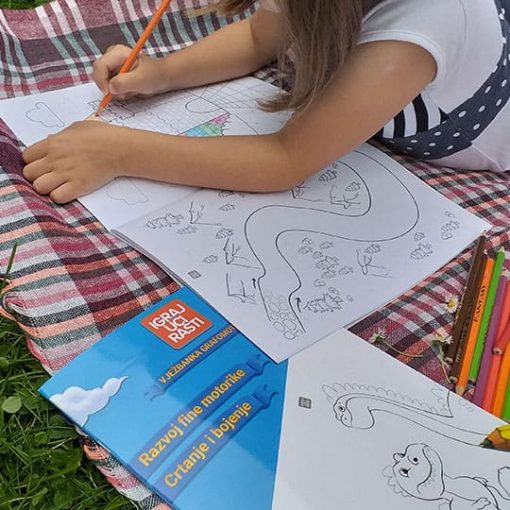 Djevojčica boji dvorac i vježba pisanje linija