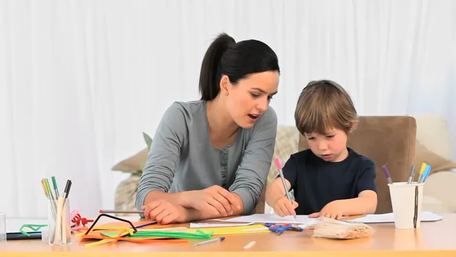 dječak pokazuje mami kako piše slova